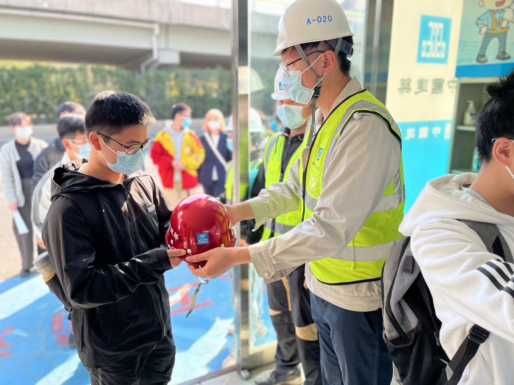4项目员工为学生佩戴安全帽.jpg